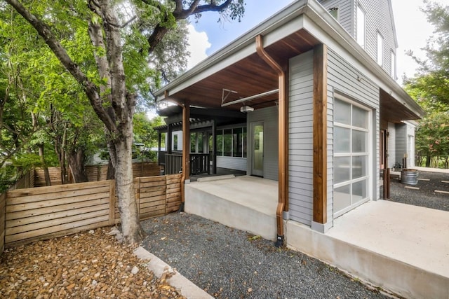 view of side of home featuring a garage and fence