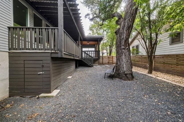 view of property exterior with stairway, fence, a deck, and a pergola