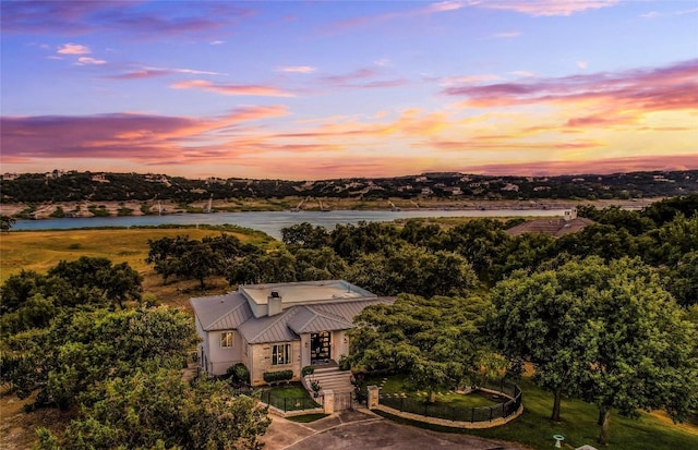 aerial view at dusk featuring a water view