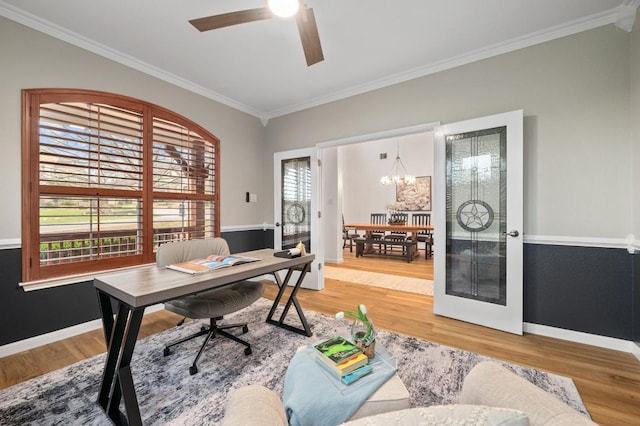 office space with hardwood / wood-style floors, crown molding, and ceiling fan with notable chandelier