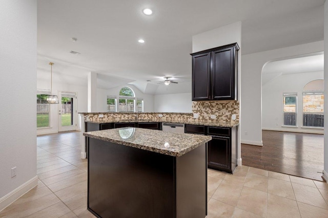 578 Ledge Stone Dr, Austin, TX 78737 - kitchen featuring tasteful backsplash, light stone counters, vaulted ceiling, light tile patterned floors, and open floor plan