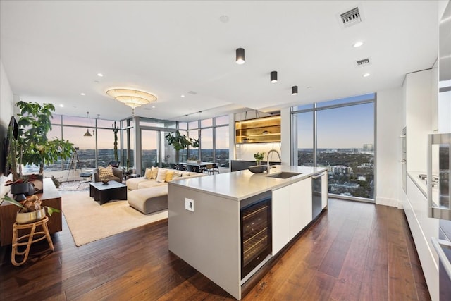 501 W Ave Unit 2904, Austin, TX 78701 - kitchen featuring modern cabinets, wine cooler, expansive windows, dark wood-type flooring, and white cabinets