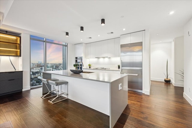 501 W Ave Unit 2904, Austin, TX 78701 - kitchen with modern cabinets, dark wood finished floors, a center island, white cabinetry, and recessed lighting