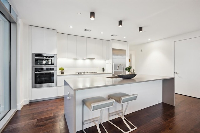 501 W Ave Unit 2904, Austin, TX 78701 - kitchen featuring modern cabinets, gas cooktop, dark wood finished floors, a kitchen island with sink, and recessed lighting