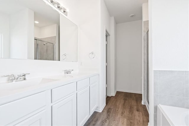 bathroom with vanity, shower with separate bathtub, and hardwood / wood-style floors