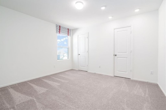 unfurnished room featuring light carpet