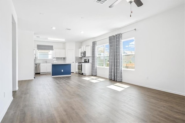 unfurnished living room with ceiling fan and wood-type flooring