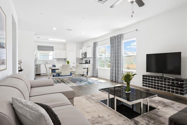 living room featuring hardwood / wood-style flooring and ceiling fan