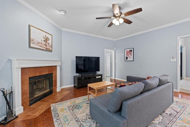 living room with hardwood / wood-style flooring, ceiling fan, crown molding, and a fireplace