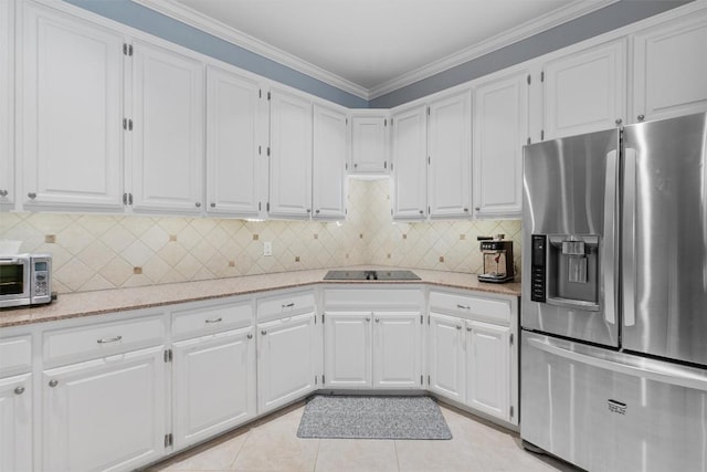 kitchen with white cabinetry, light stone countertops, stainless steel fridge, ornamental molding, and light tile patterned floors