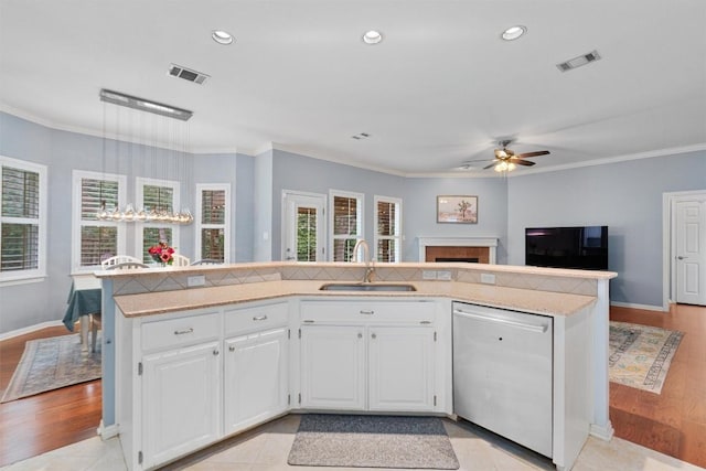 kitchen with stainless steel dishwasher, sink, white cabinetry, and a center island with sink