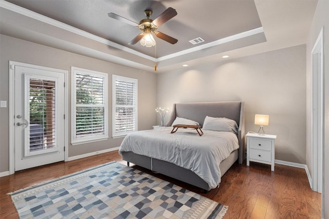 bedroom with a tray ceiling, ceiling fan, dark wood-type flooring, access to exterior, and ornamental molding