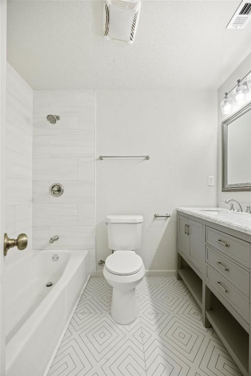 full bathroom with tile patterned flooring, toilet, vanity, and tiled shower / bath