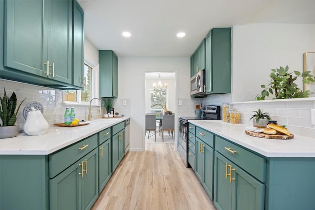 kitchen featuring appliances with stainless steel finishes, light hardwood / wood-style flooring, plenty of natural light, and green cabinets