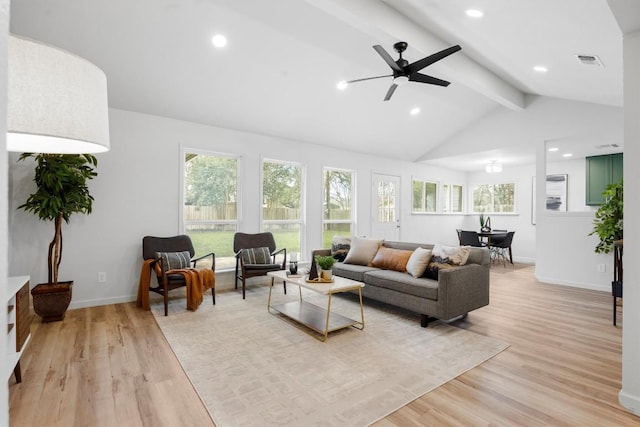 living room with light wood-type flooring, vaulted ceiling with beams, and a healthy amount of sunlight