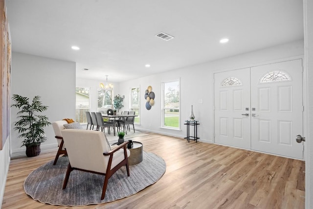 entryway featuring a notable chandelier, light hardwood / wood-style flooring, and a healthy amount of sunlight