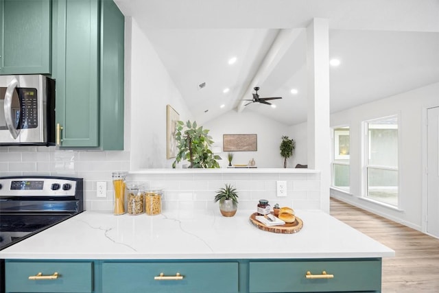 kitchen featuring green cabinetry, lofted ceiling, stainless steel appliances, and light stone counters