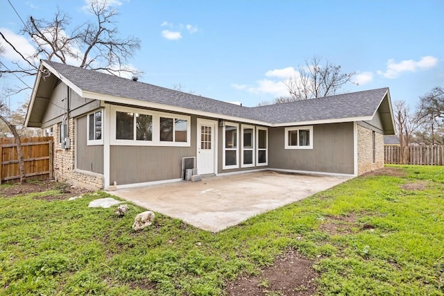 rear view of house featuring a lawn and a patio