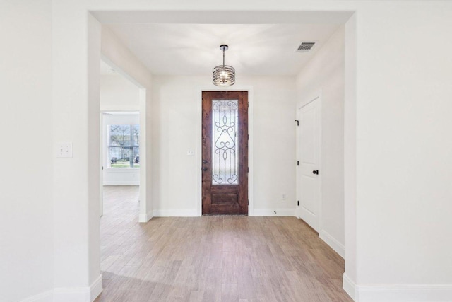 entrance foyer featuring baseboards, visible vents, an inviting chandelier, and light wood-type flooring