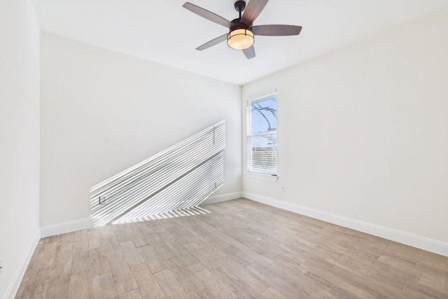 unfurnished room with baseboards, ceiling fan, and wood finished floors