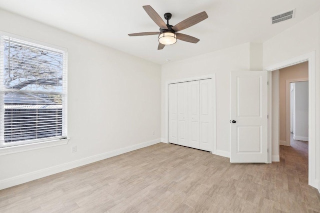 unfurnished bedroom featuring light wood-style floors, baseboards, visible vents, and multiple windows