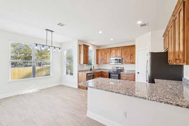 kitchen featuring a sink, visible vents, brown cabinets, and appliances with stainless steel finishes