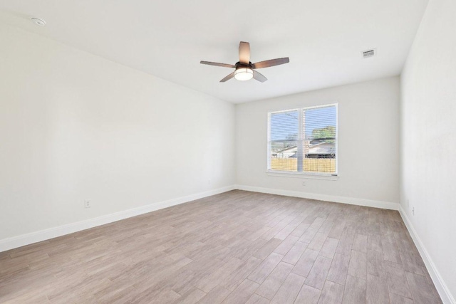 unfurnished room featuring baseboards, ceiling fan, visible vents, and light wood-style floors
