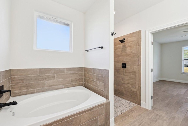 bathroom featuring wood finished floors, tiled shower, and a bath