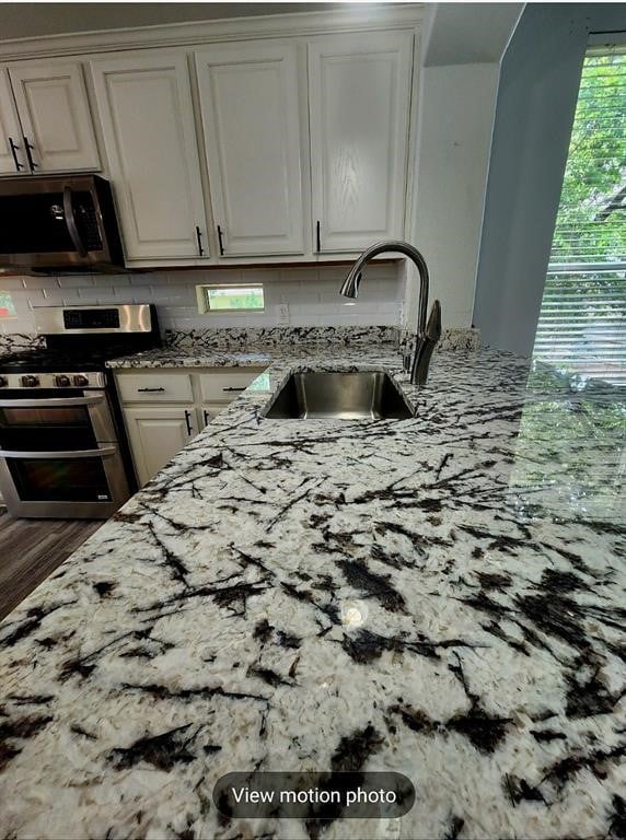 2500 National Park Blvd, Austin, TX 78747 - kitchen featuring appliances with stainless steel finishes, light stone countertops, and decorative backsplash