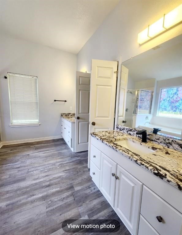 2500 National Park Blvd, Austin, TX 78747 - full bath with lofted ceiling, a shower stall, vanity, wood finished floors, and a garden tub