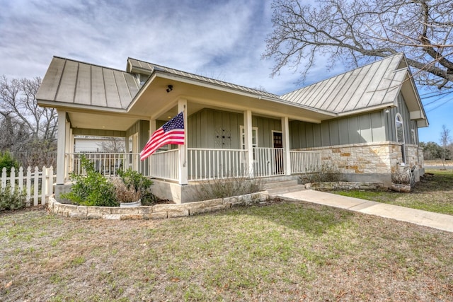 single story home featuring covered porch and a front yard