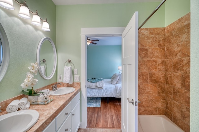 bathroom featuring tiled shower / bath combo and vanity