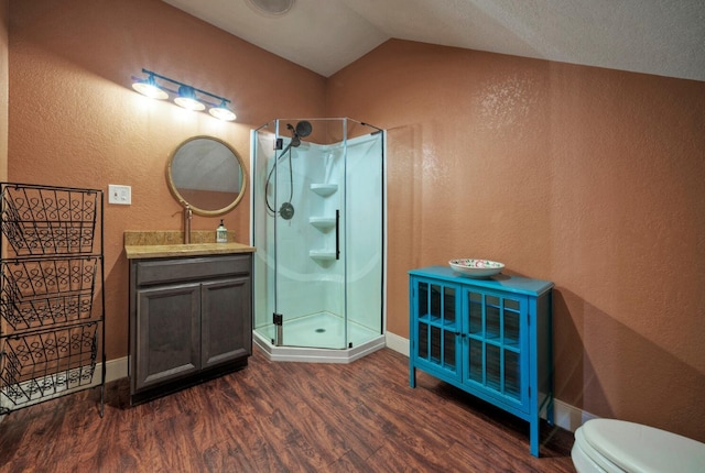 bathroom featuring lofted ceiling, wood-type flooring, vanity, an enclosed shower, and toilet