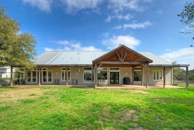 rear view of property with french doors, a yard, and a patio area