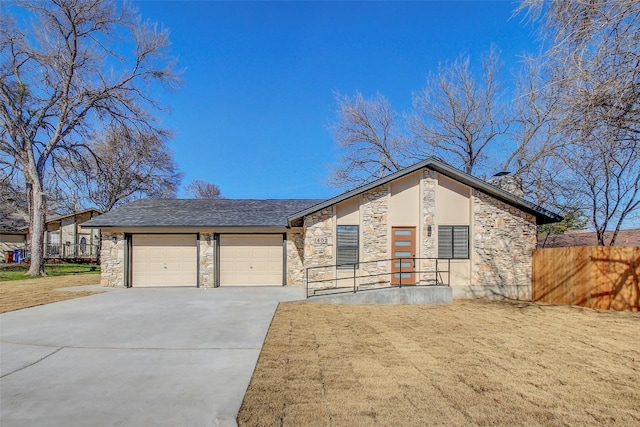 mid-century modern home featuring a garage, stone siding, and concrete driveway