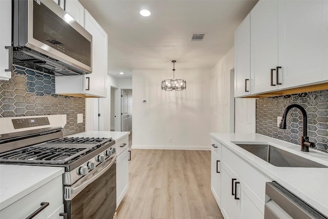 1402 Valleyridge Cir, Austin, TX 78704 - kitchen with appliances with stainless steel finishes, decorative backsplash, light wood-type flooring, light stone countertops, and recessed lighting