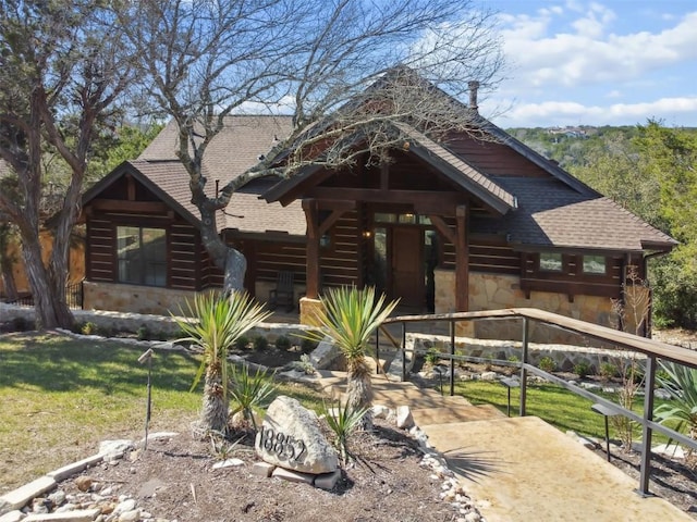 log home featuring stone siding and roof with shingles