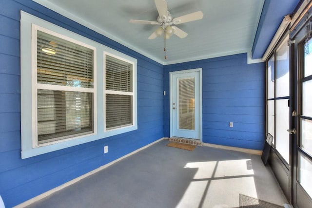 unfurnished sunroom with ceiling fan