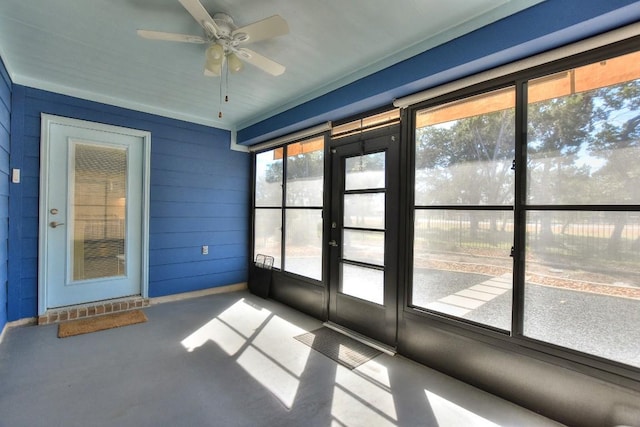 unfurnished sunroom with ceiling fan