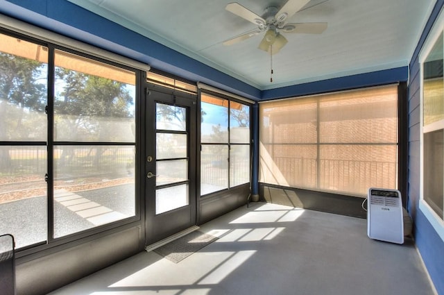 unfurnished sunroom with ceiling fan