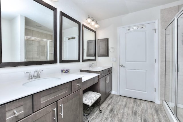 bathroom with vanity, a shower with shower door, and hardwood / wood-style floors