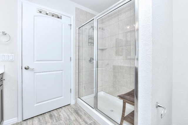 bathroom with a shower with door, wood-type flooring, and vanity