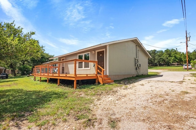 rear view of house featuring a yard and a wooden deck