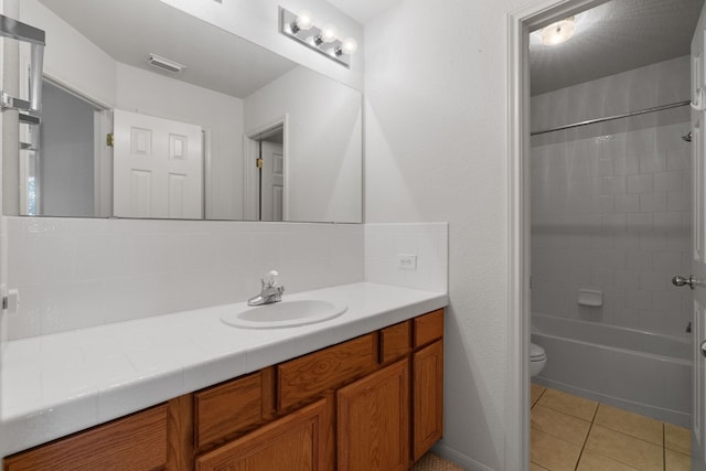 full bathroom with toilet, vanity, tile patterned flooring, and tiled shower / bath combo