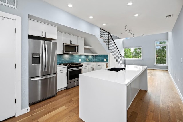 2002 E 7th St Unit 204, Austin, TX 78702 - kitchen with stainless steel appliances, a sink, light countertops, light wood-style floors, and recessed lighting