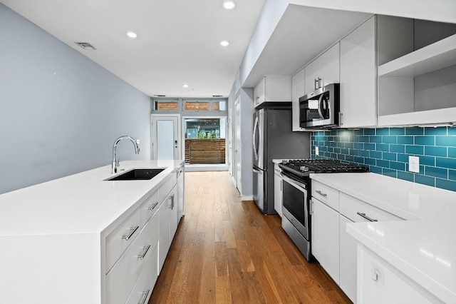 2002 E 7th St Unit 204, Austin, TX 78702 - kitchen with appliances with stainless steel finishes, a sink, dark wood-style floors, recessed lighting, and light countertops