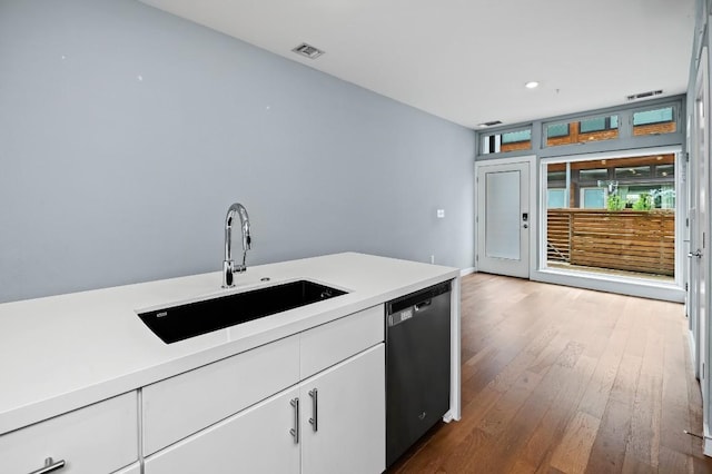 2002 E 7th St Unit 204, Austin, TX 78702 - kitchen with dishwasher, a sink, light countertops, white cabinetry, and wood finished floors