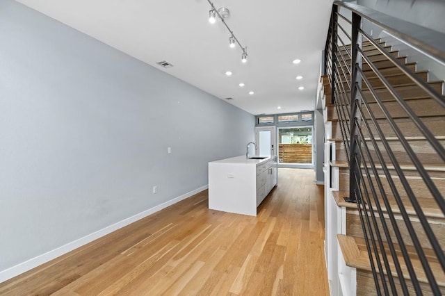 2002 E 7th St Unit 204, Austin, TX 78702 - kitchen with a sink, baseboards, light wood-style floors, recessed lighting, and a kitchen island with sink