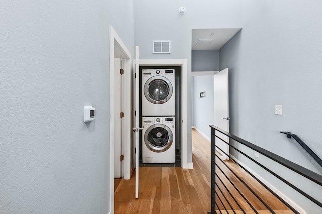 2002 E 7th St Unit 204, Austin, TX 78702 - washroom with stacked washer / dryer and wood finished floors