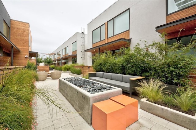 view of home's community featuring a patio area and an outdoor living space with a fire pit